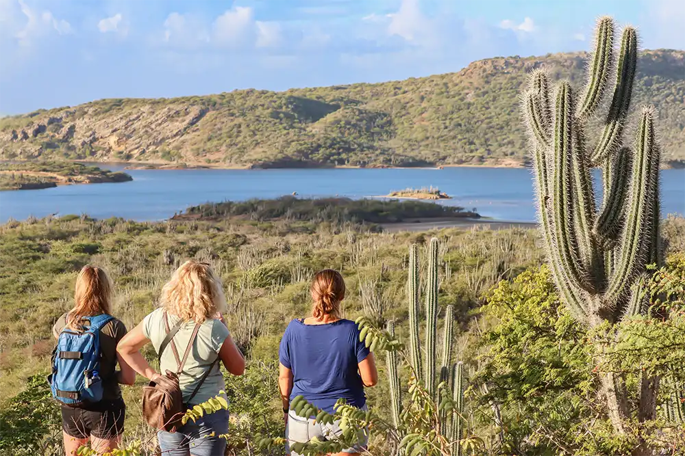 Three ladies enjoying the view over Goto Lake during their hiking excursion on Bonaire.